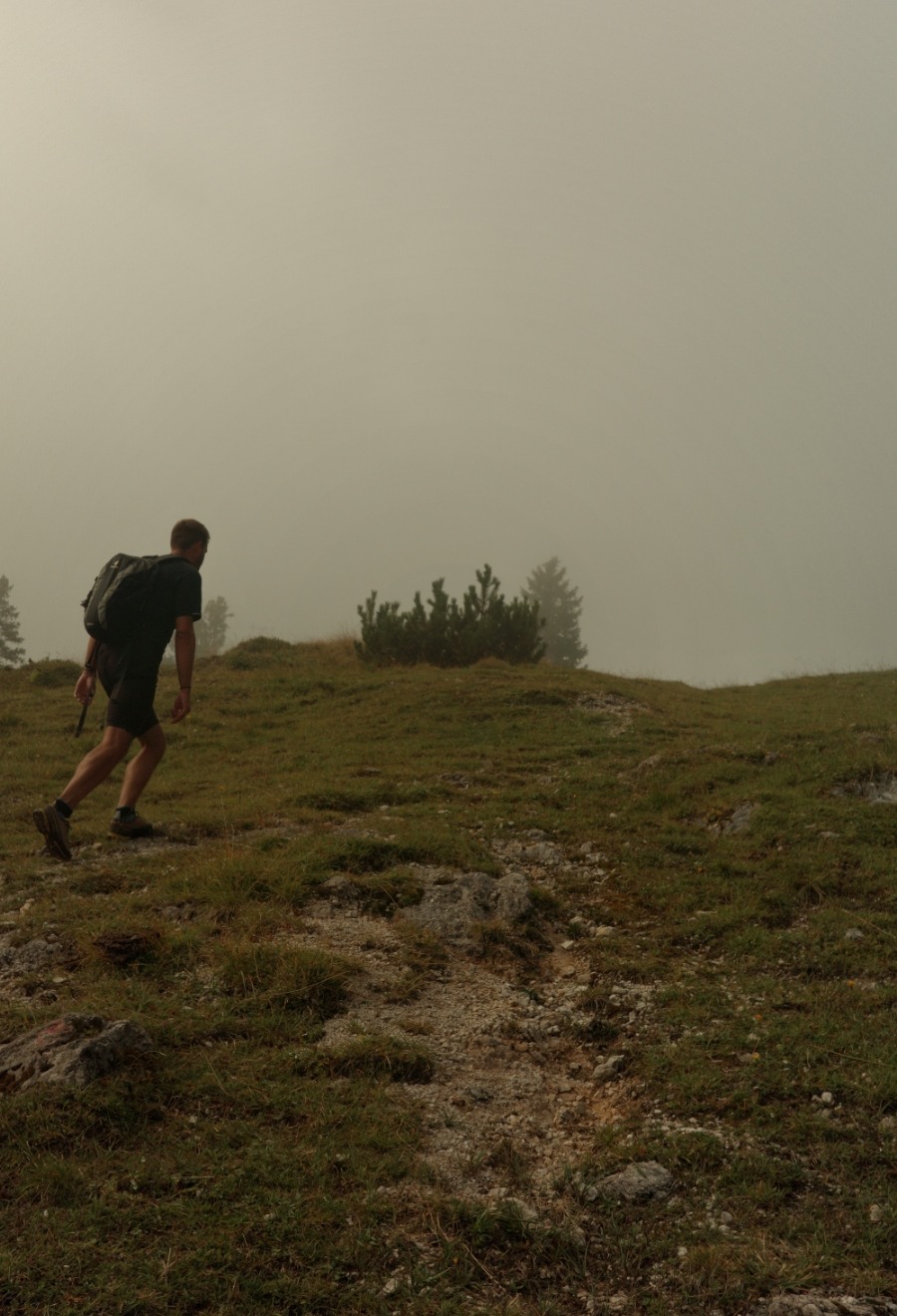 Detail14 Wanderer auf einem steilen Almweg im Nebel Richtung Rosskogelsattel