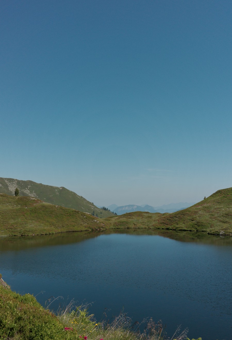 Mittlerer Wildalmsee zwischen grünen Bergrücken mit weitem Alpenblick