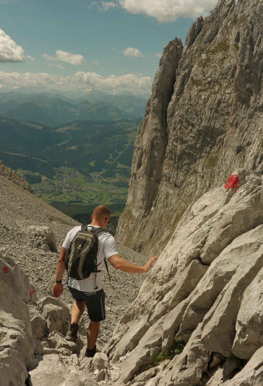 Wanderer auf einem rot-weiß-rot markierten Felsweg nahe dem Ellmauer Tor