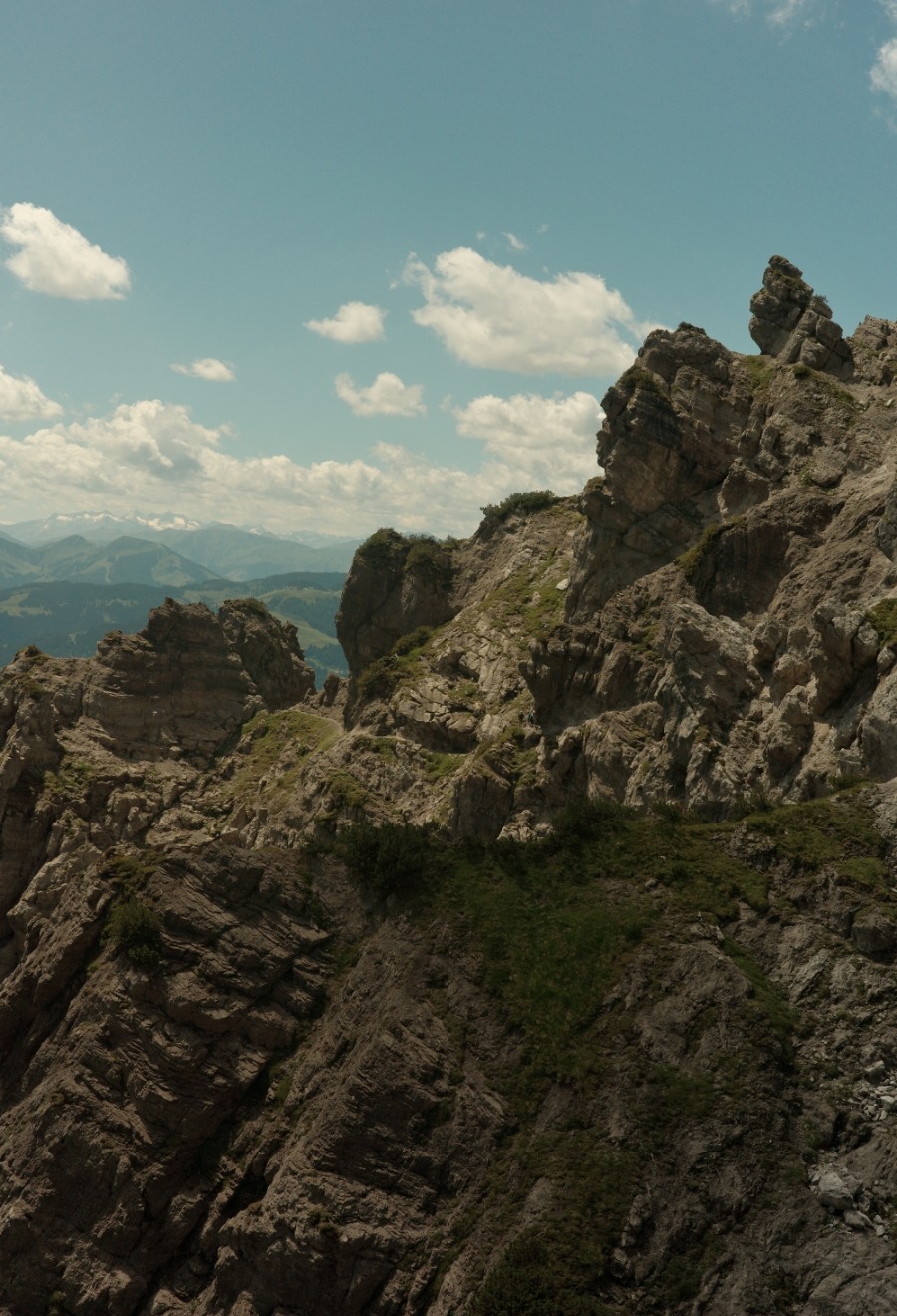Zerklüftete Felsformationen am Jubiläumssteig mit Blick in die Tiroler Bergwelt